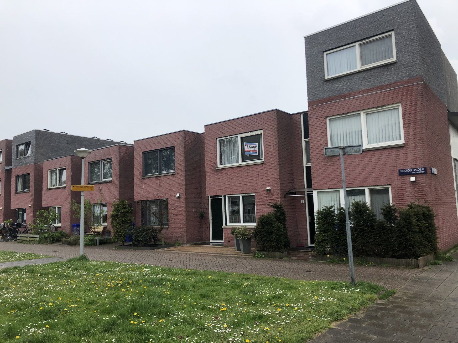 Een rij bakstenen huizen die naast elkaar staan ​​in een woonwijk.