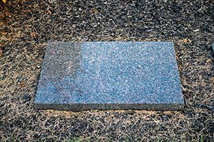 A gray granite slab is sitting on top of a pile of gravel.