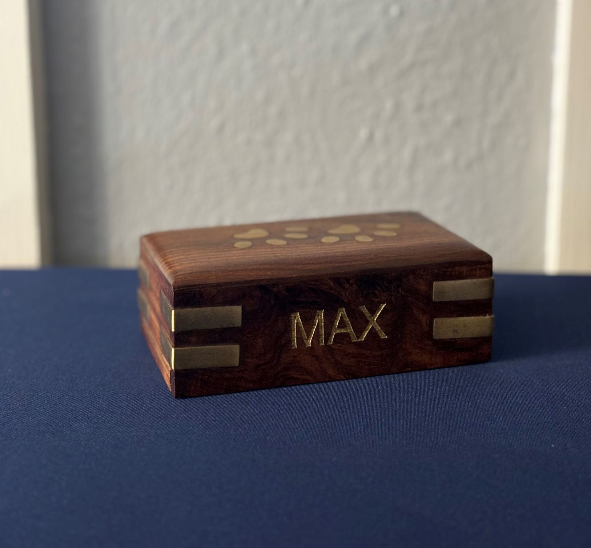 Three wooden boxes with locks and flowers on a table.