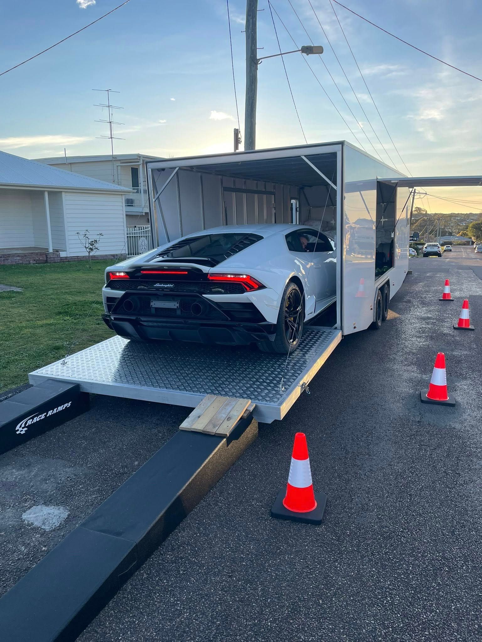 White Trailer with Car Inside Parked on Street, Orange Cones — Full Throttle Enclosed Car Transport in Kilmore, VIC