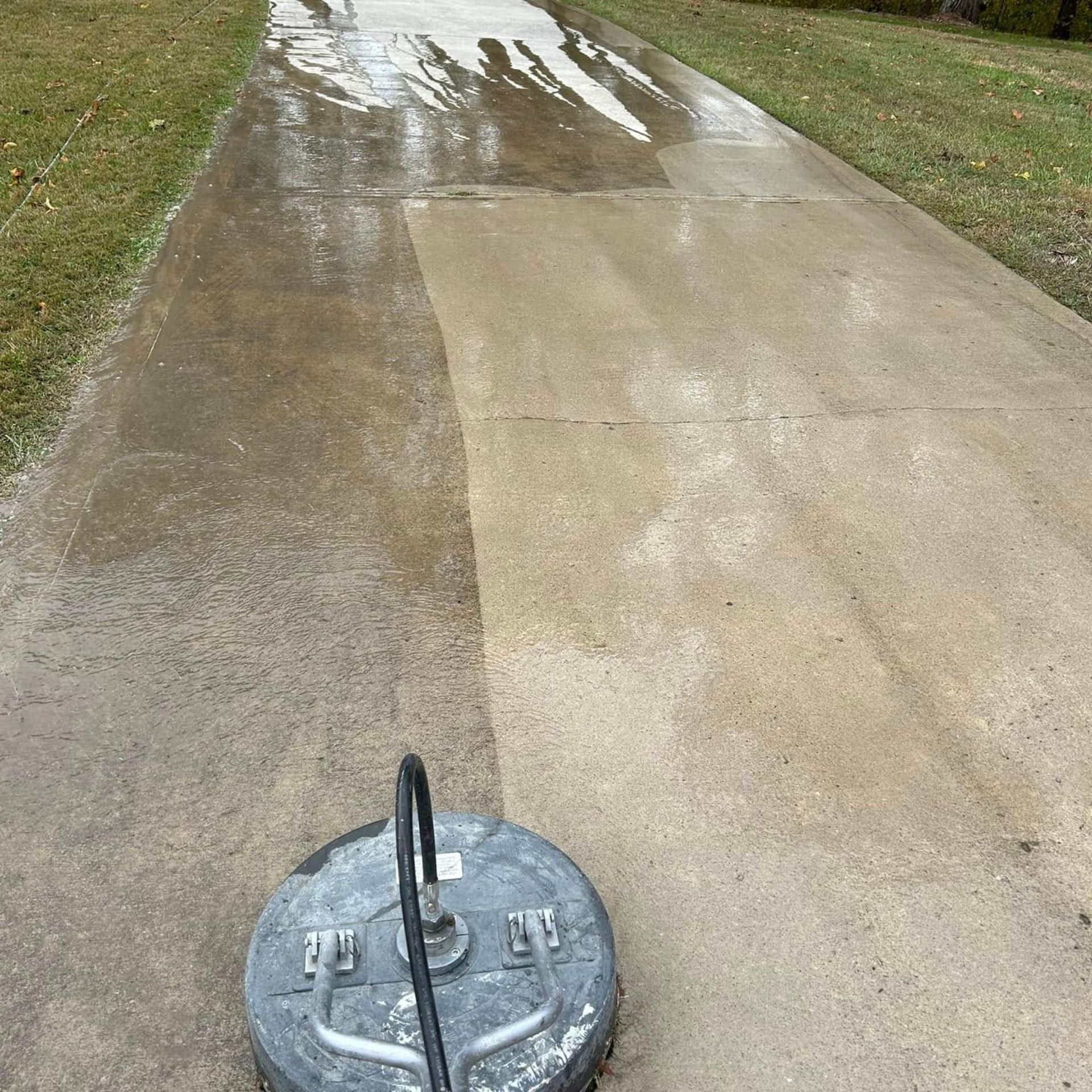 Pressure Pros and Soft Washing - A concrete driveway being pressure washed; one side is clean, other is dirty.