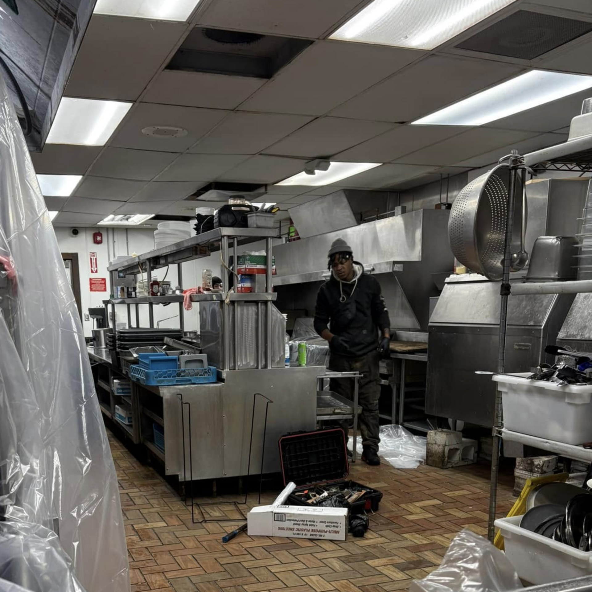 Pressure Pros and Soft Washing - Man in kitchen with equipment and stainless steel appliances.