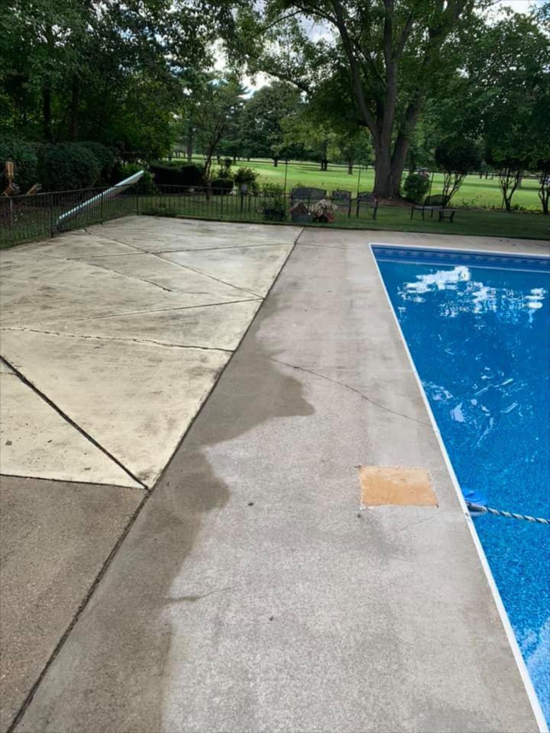 Pressure Pros Soft Washing LLC | swimming pool with a concrete deck next to it.