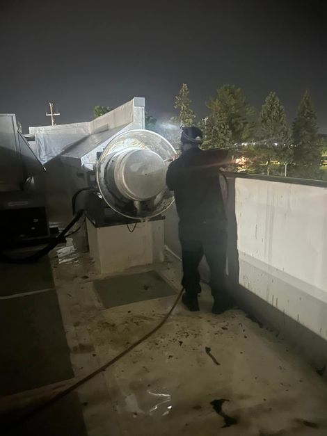 Pressure Pros Soft Washing LLC | man is standing on the roof of a building at night.