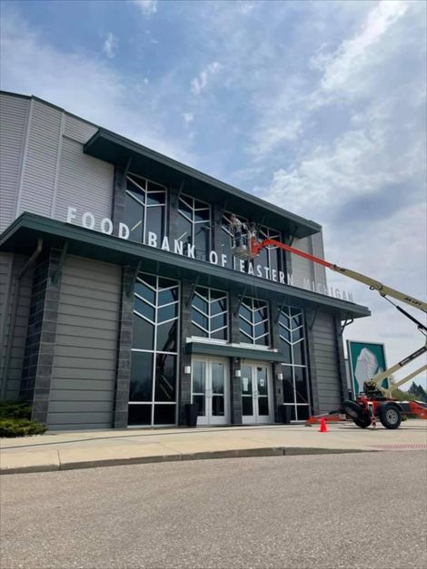 Pressure Pros Soft Washing LLC | large building with a lot of windows is being cleaned by a crane.