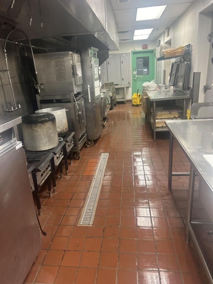 Pressure Pros Soft Washing LLC | kitchen with a red tile floor and stainless steel appliances.