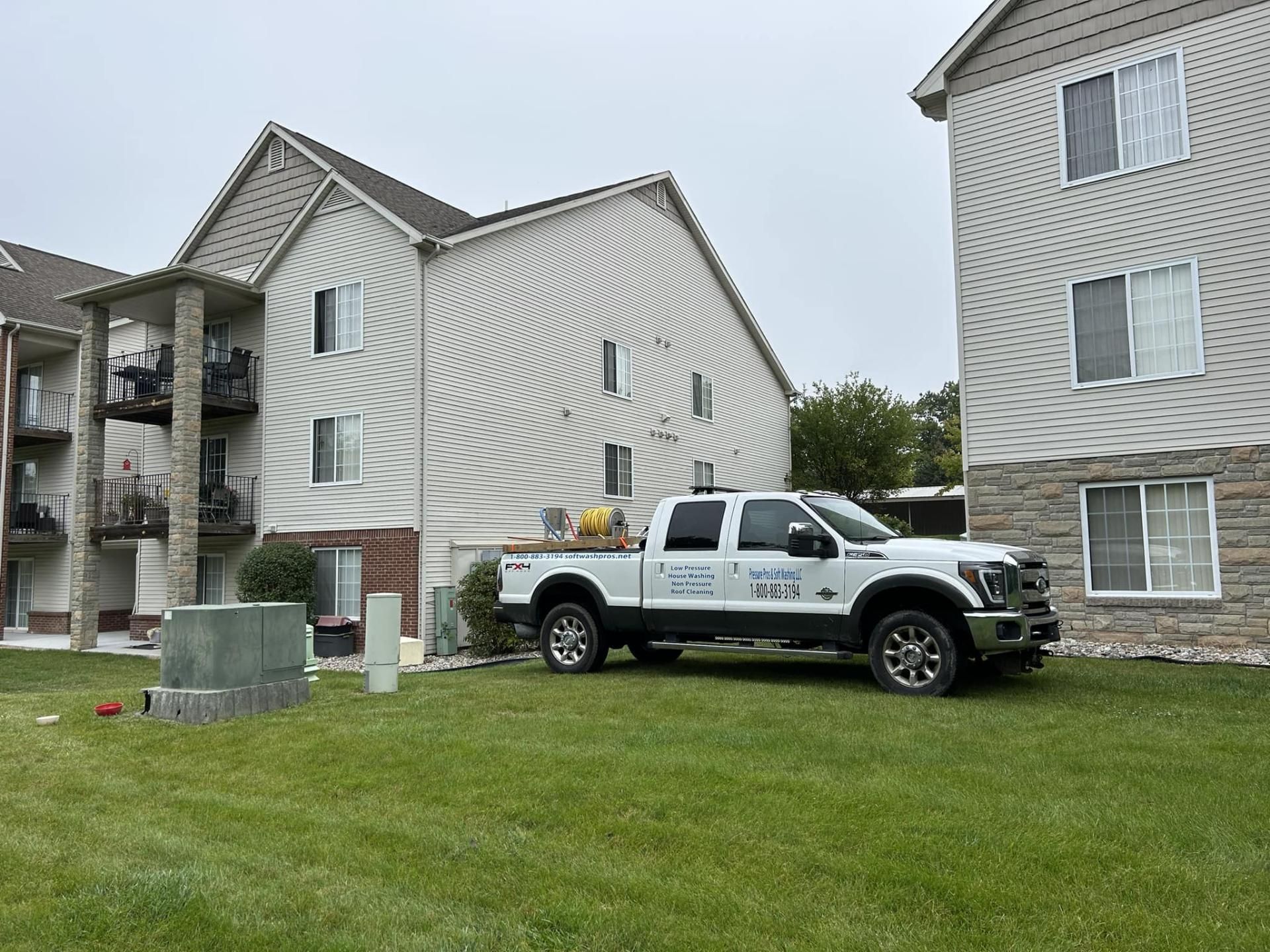 Pressure Pros Soft Washing LLC | white truck is parked in front of a building.