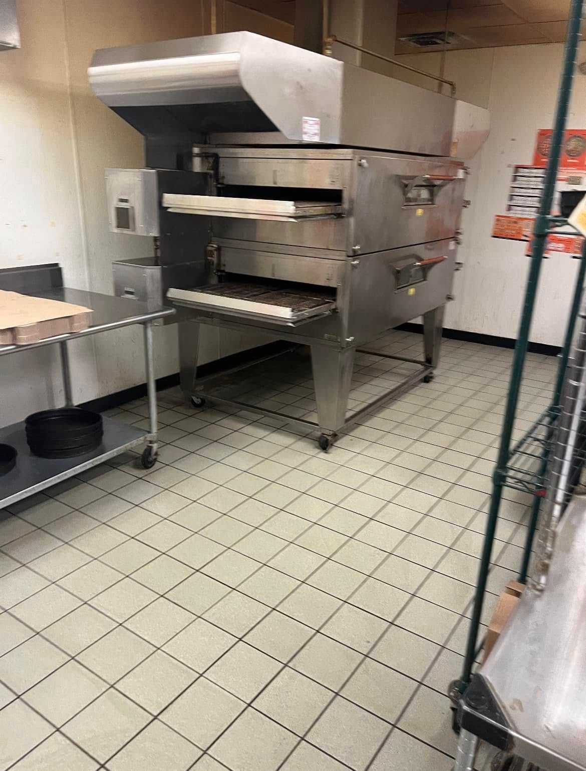 Pressure Pros Soft Washing LLC | concrete driveway is being cleaned with a pressure washer.