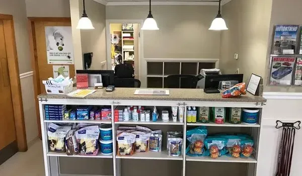 A veterinarian's office with a counter and shelves filled with pet supplies.