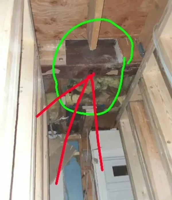 A green circle with red arrows pointing to it is in the ceiling of a room.