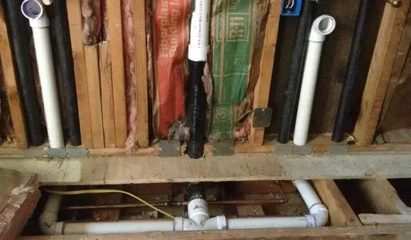A bunch of pipes are connected to a wall in a room.