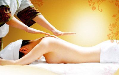 Woman receiving a back massage at a spa, with hands on her back.