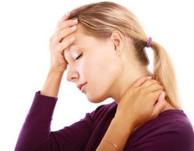Woman with hand on forehead and neck, eyes closed, possibly experiencing headache or pain.