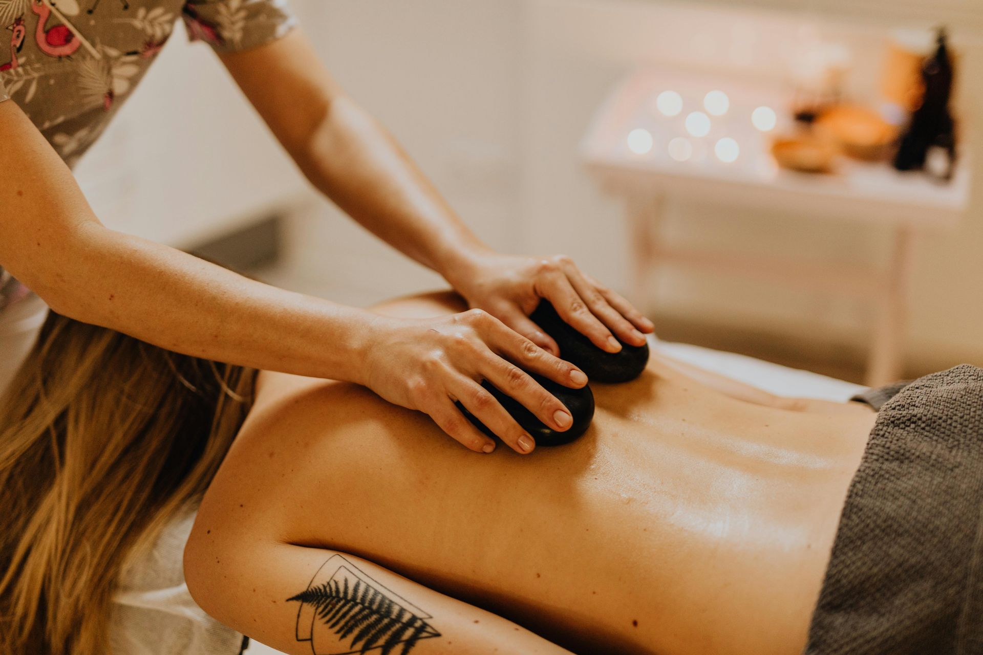 Woman receiving a hot stone massage on her back at a spa.
