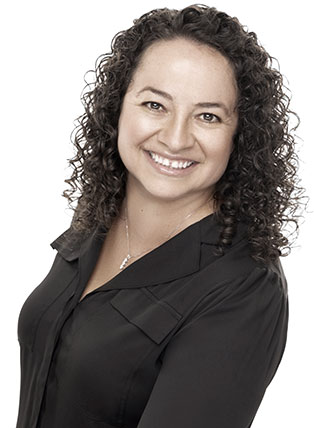Woman with curly brown hair smiles, wearing a black shirt.