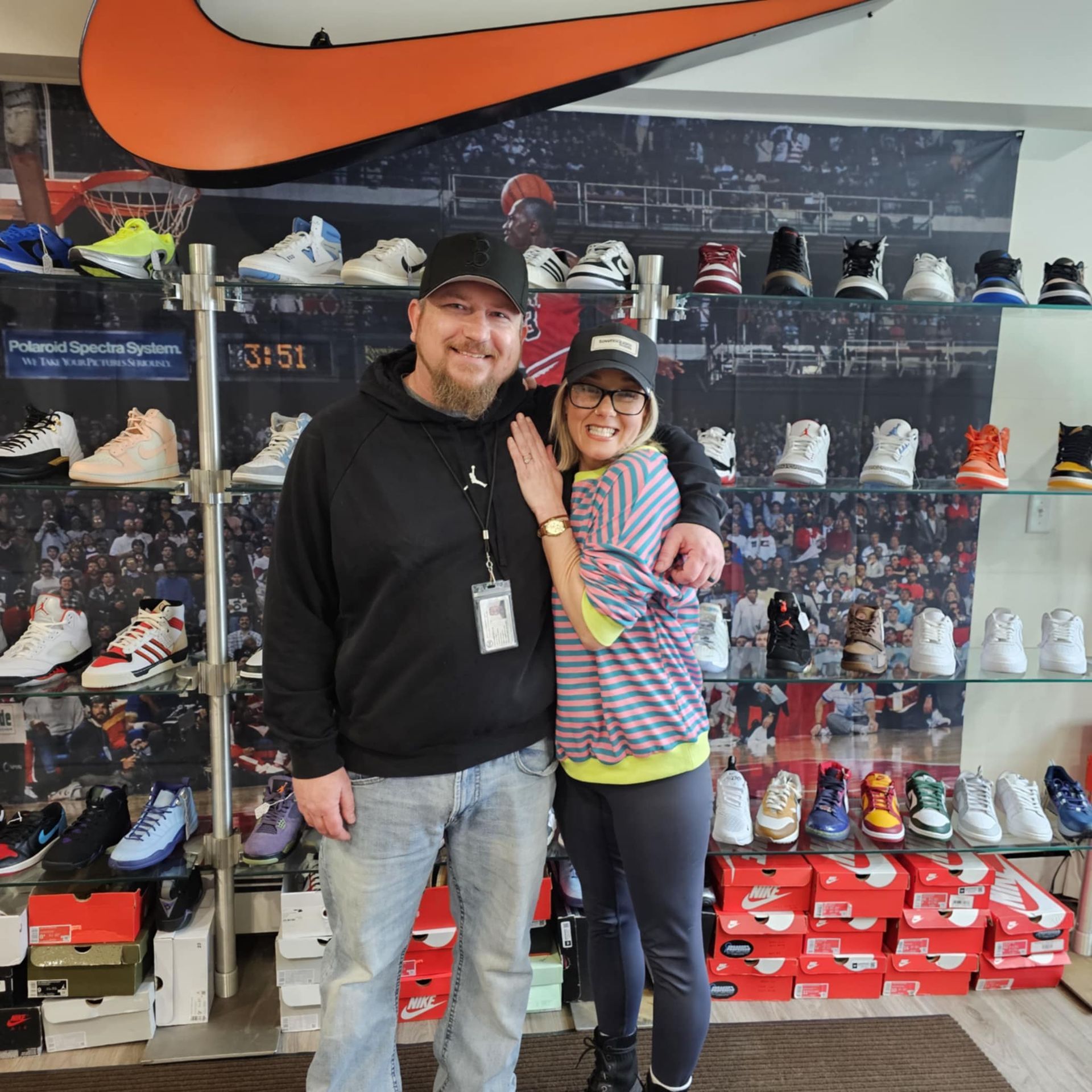 A man and a woman are posing for a picture in a nike store