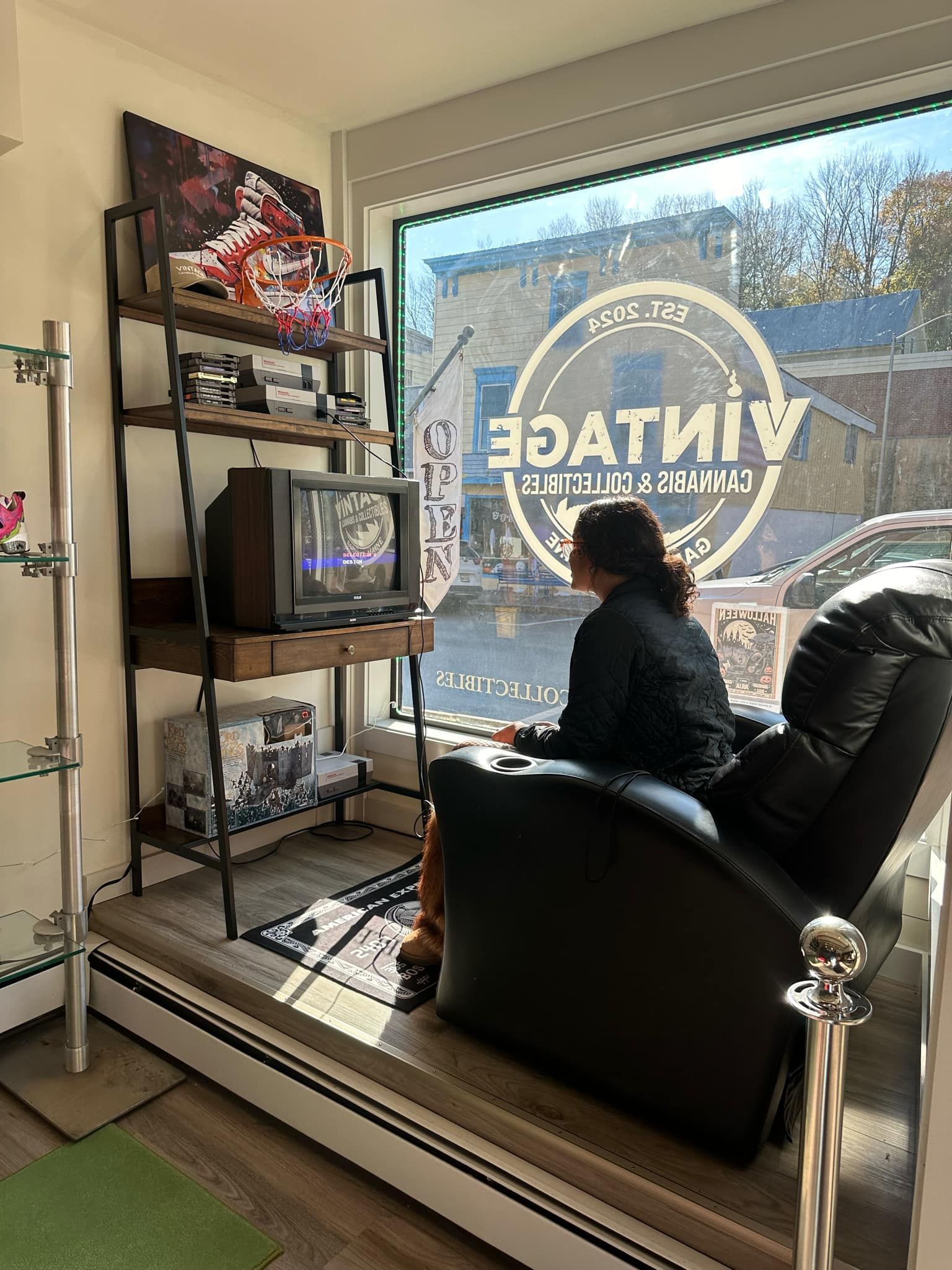 A woman is sitting in a chair in front of a window.