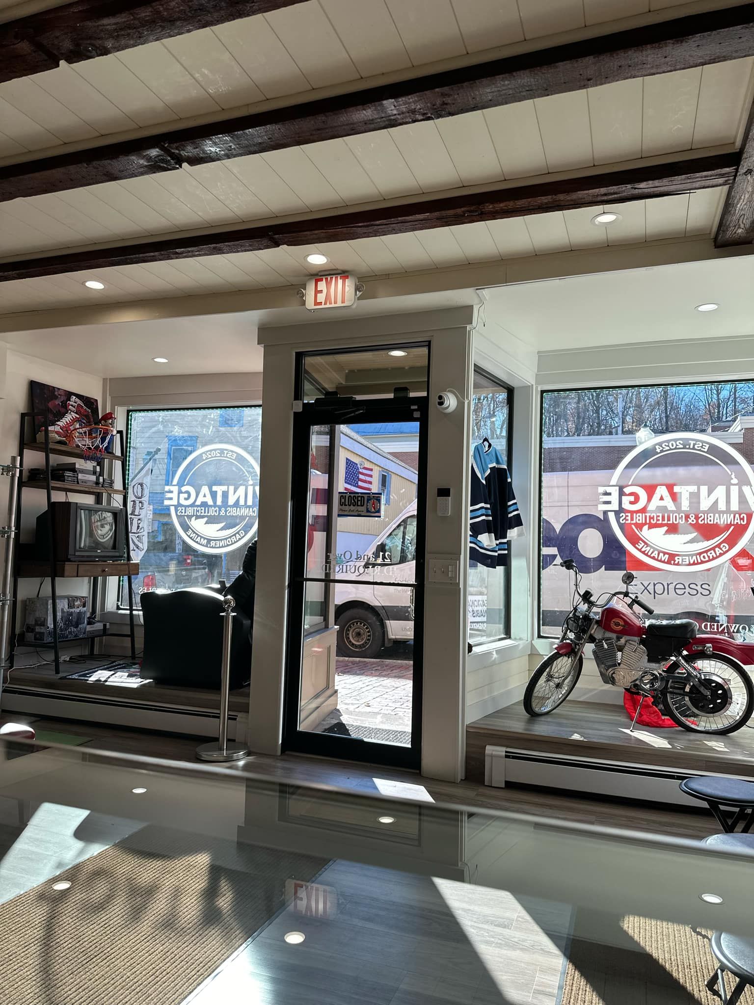 A motorcycle is parked in front of a glass door in a showroom.
