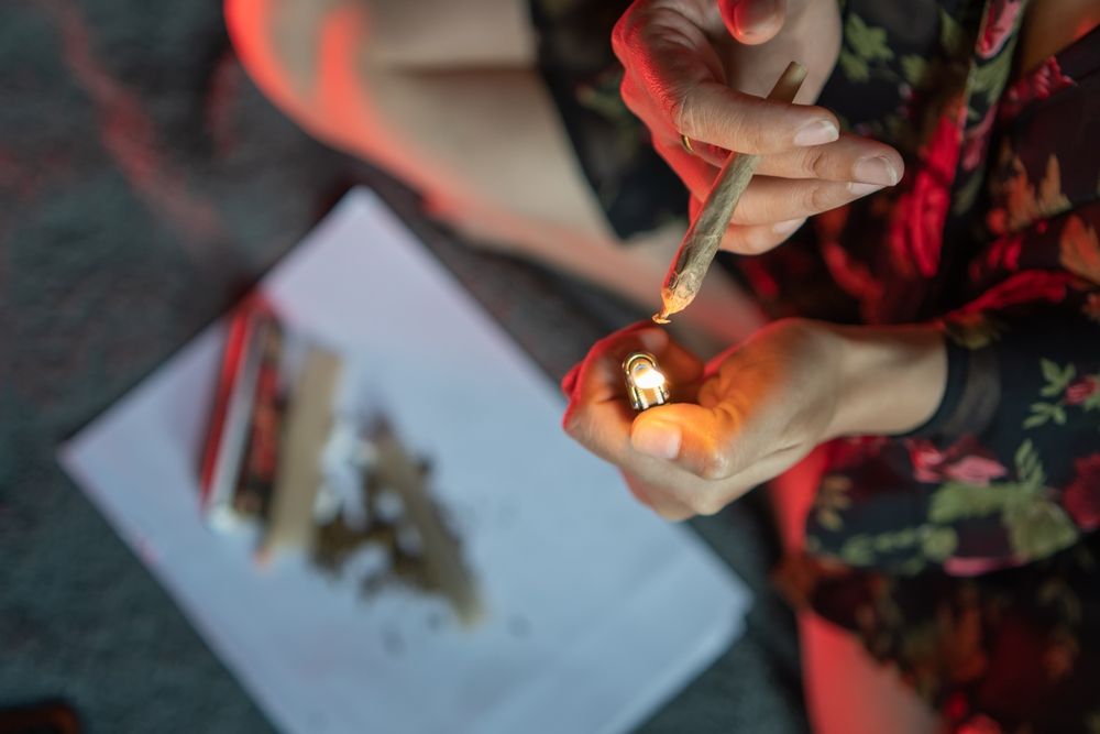 A woman is lighting a joint with a lighter.