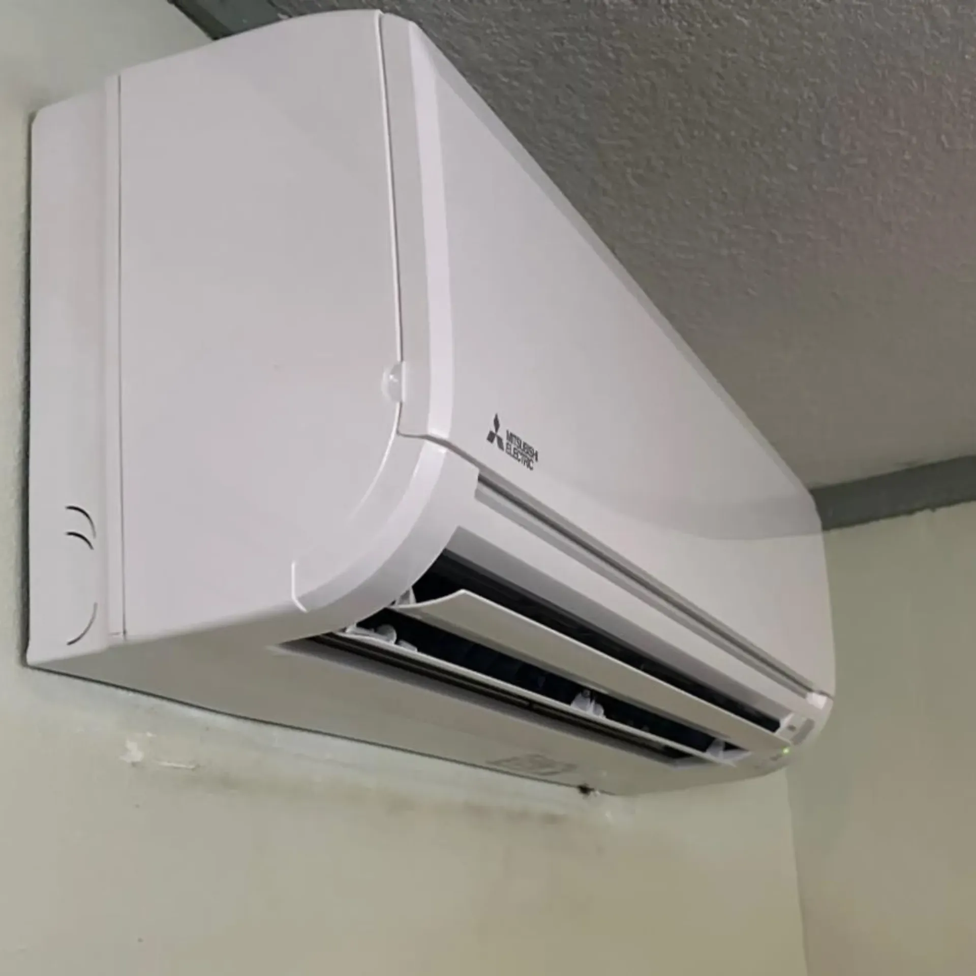 LCS Heating And Cooling - A white Mitsubishi air conditioner is mounted on a wall