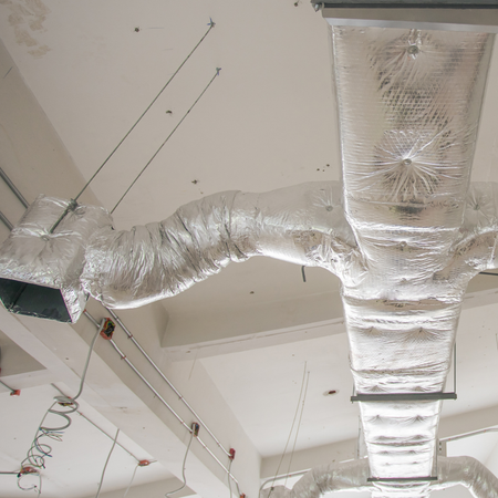 LCS Heating and Cooling - A large duct with foil wrapped around it is hanging from the ceiling