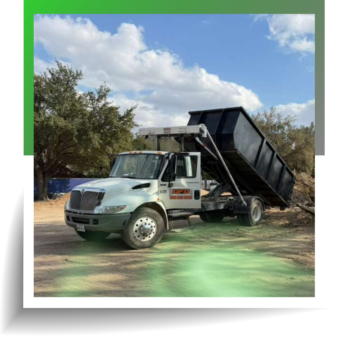 An image of two men carrying junk sofa with a dump truck behind them