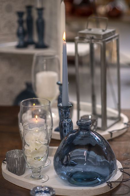 Un vassoio con candele, vasi e bicchieri sopra.