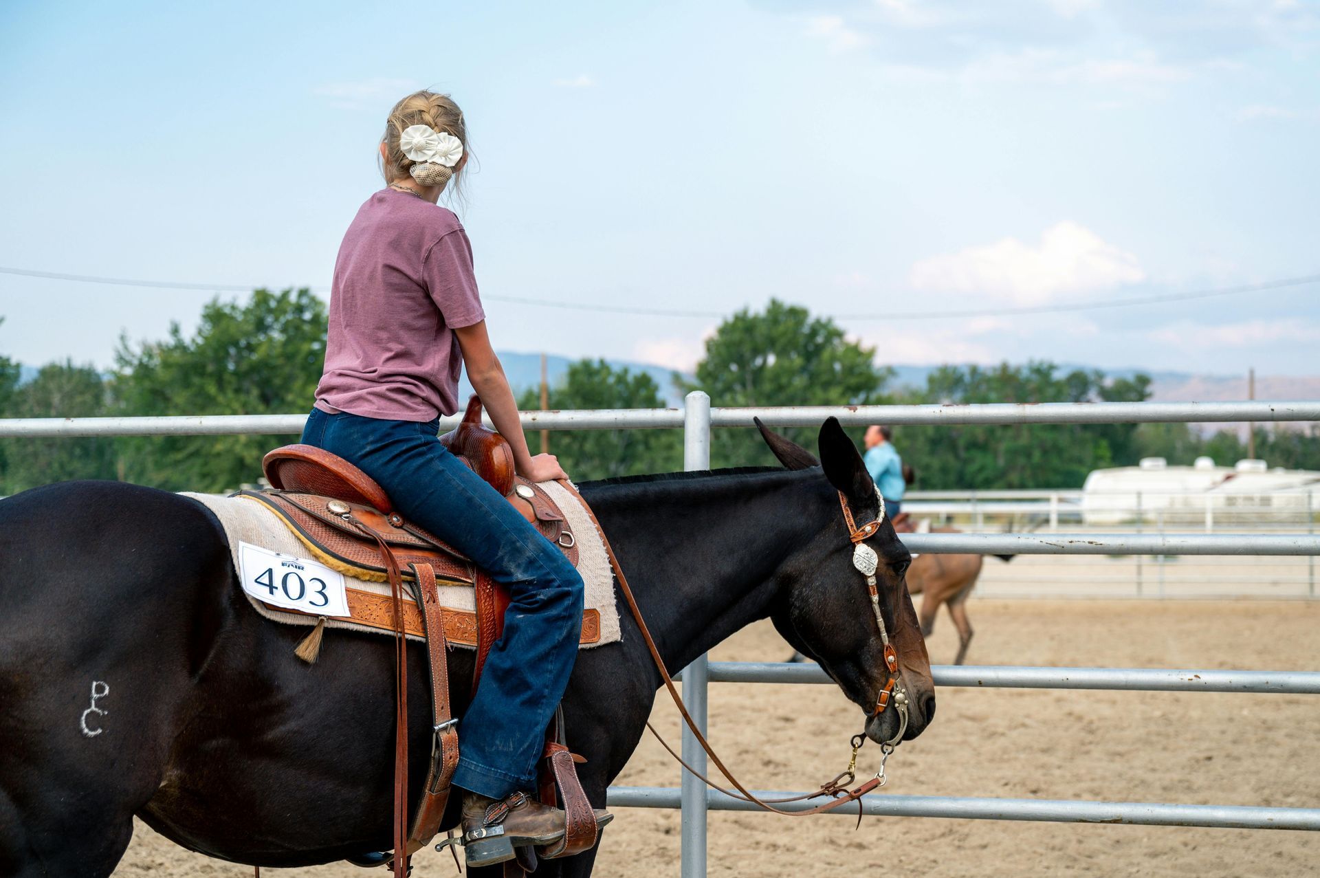 A woman is riding a horse in a fenced in area.