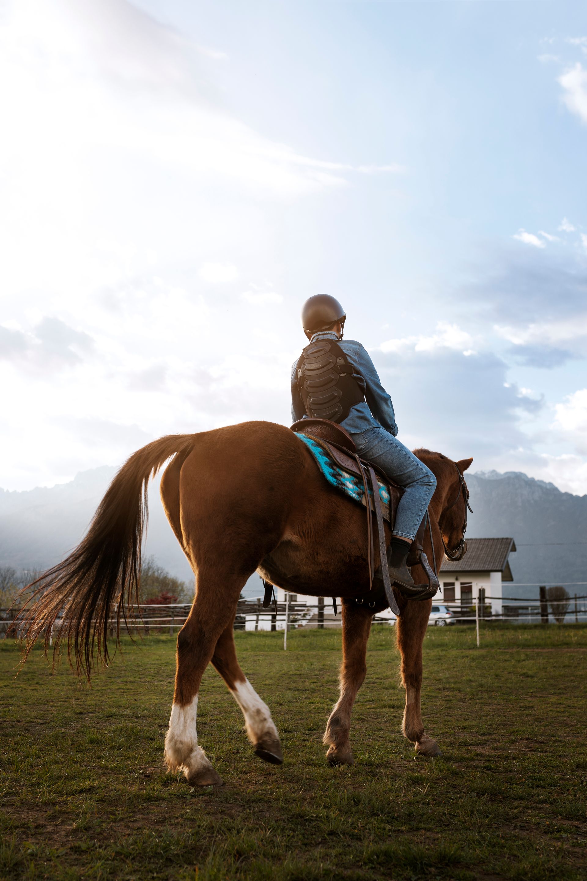 A man is riding a brown horse in a field.