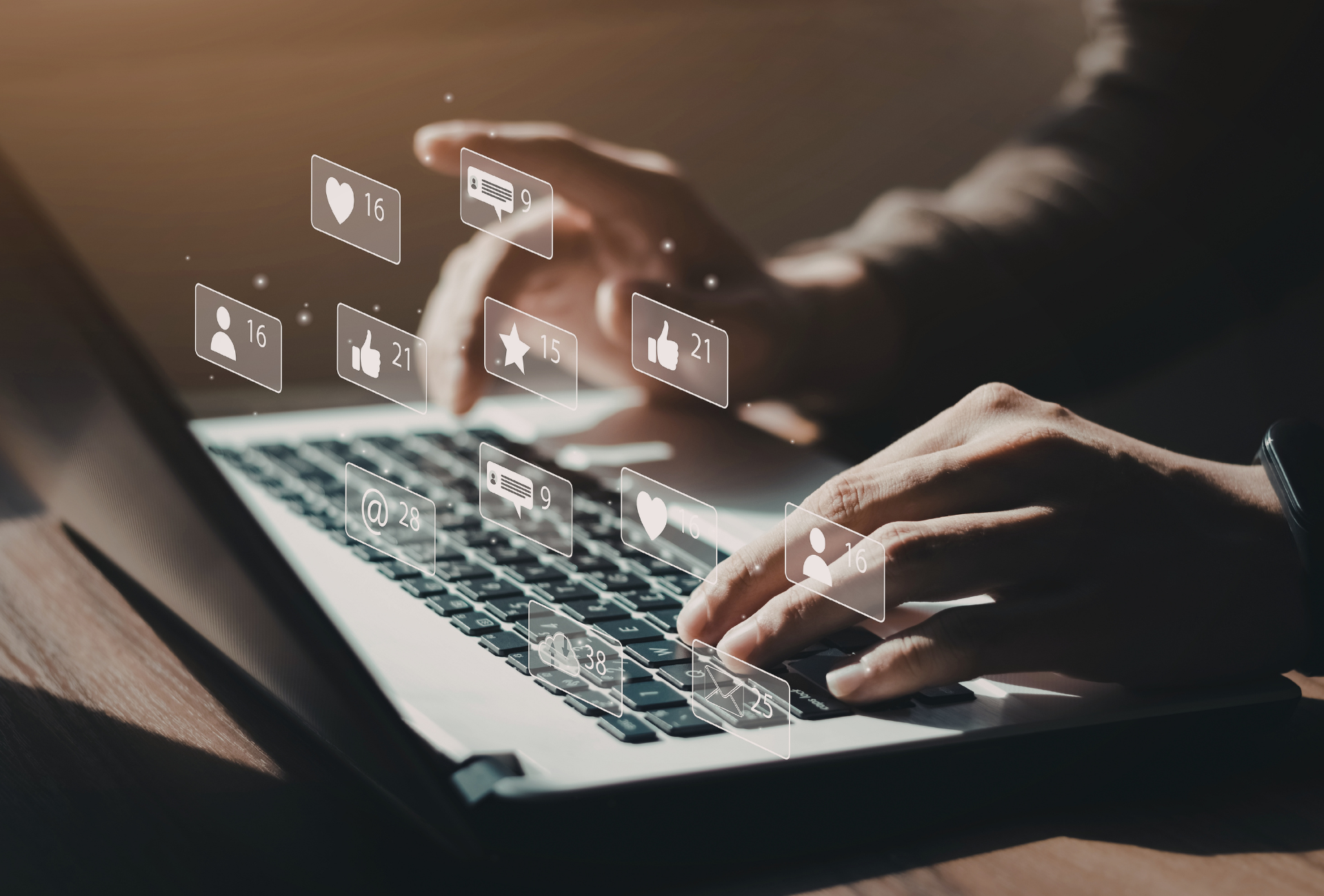A person typing on a computer surrounded by social media icons including like, comment, and follow. 