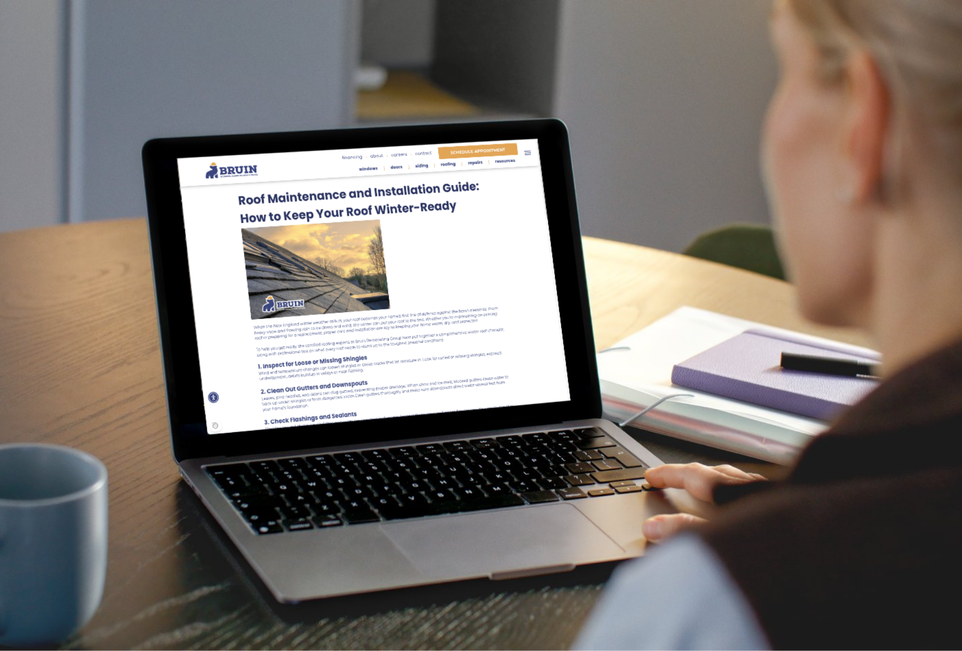 Woman reading a blog on her computer about winter roof maintenance and installation tips.