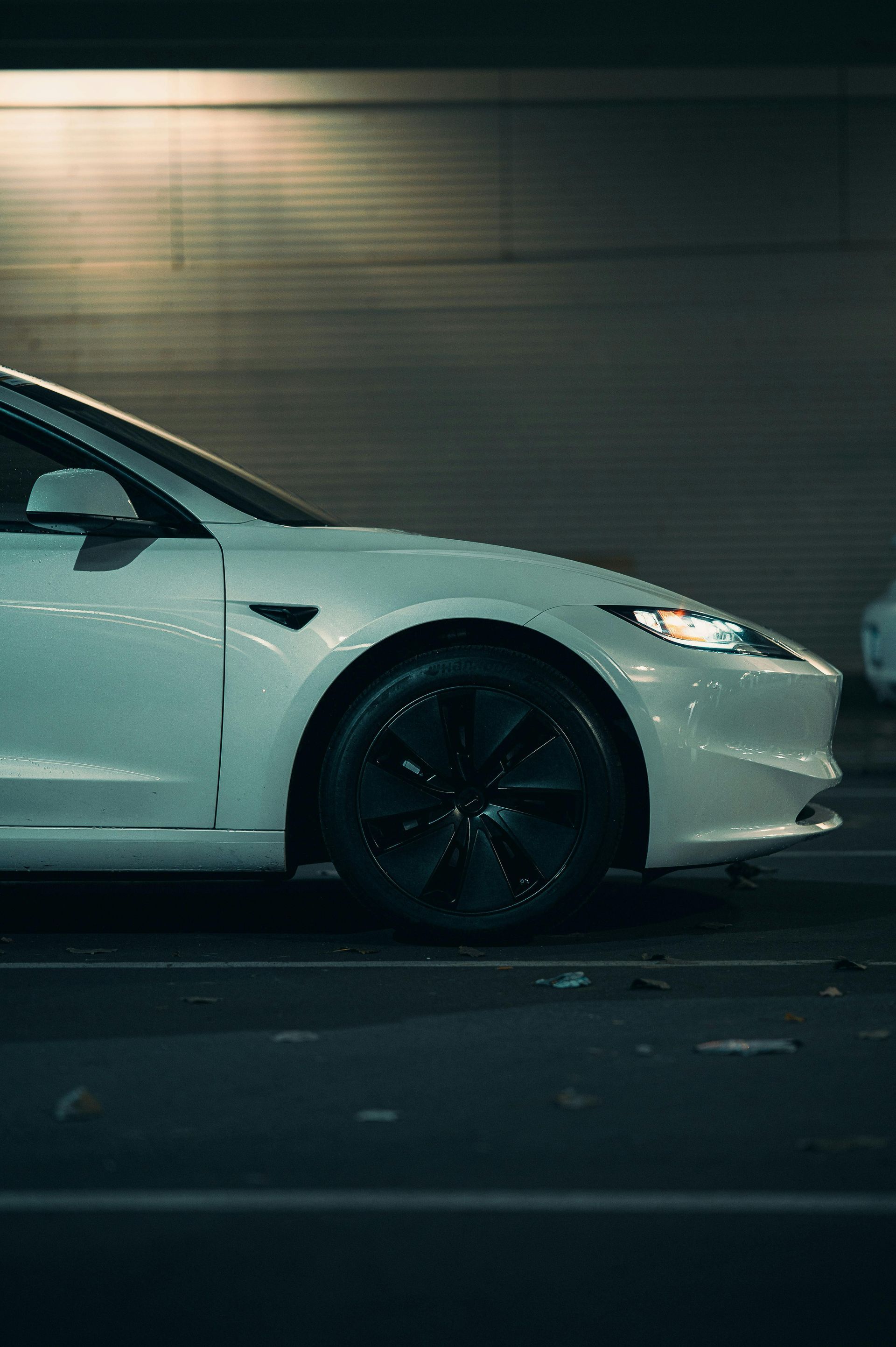 Person washing a blue car with a soapy sponge.