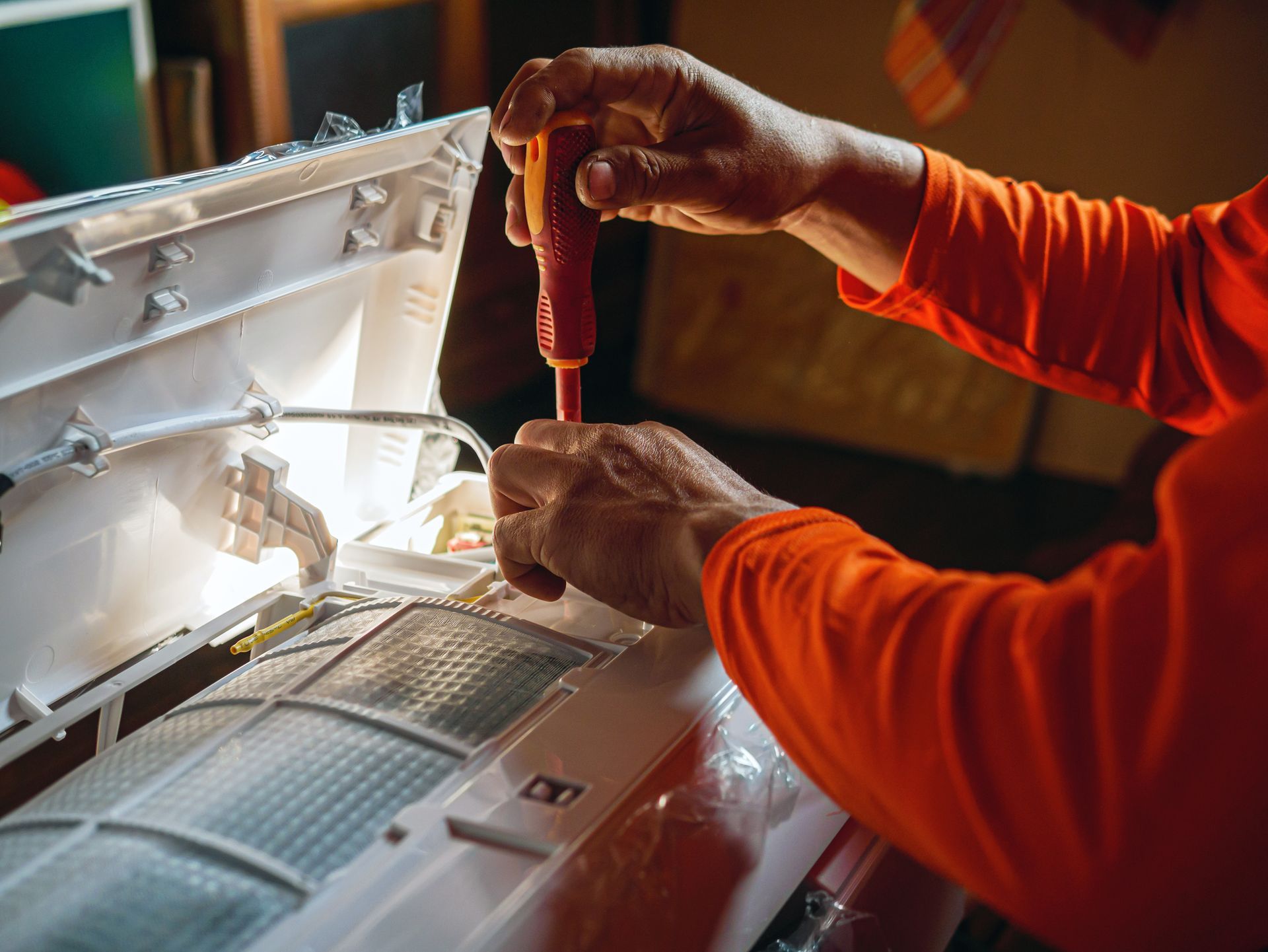 Person opening a dishwasher, toolbox in foreground.