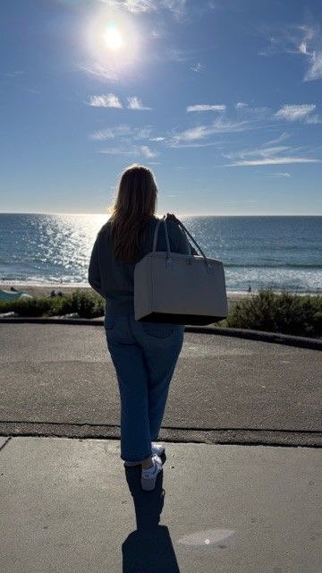 Woman carrying insulated tote bag by The Stever Co at Carlsbad beach