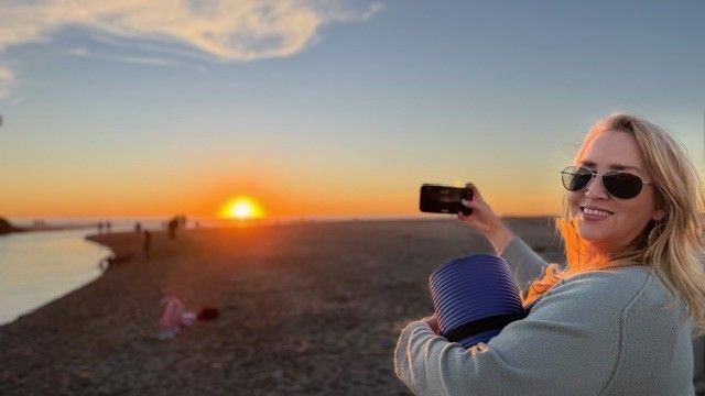 Woman with Salt & Stone insulated tote bag by The Stever Co watching beach sunset