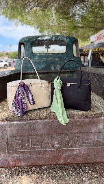 Stever Co tote bags displayed near a vintage truck at a winery