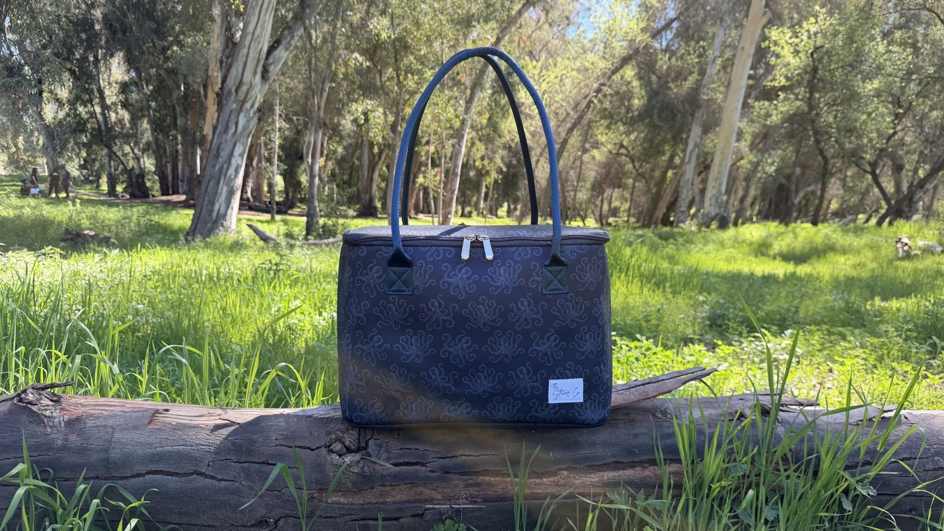 Tentacle & Tide insulated tote bag by The Stever Co outdoors on a log