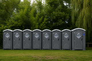 Gray portable accessible restroom with wheelchair symbol on the door