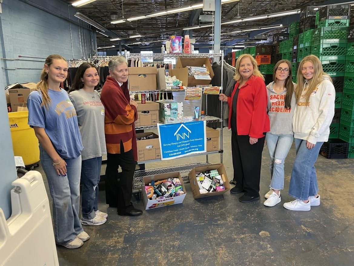 A group of people standing in front of a pile of boxes