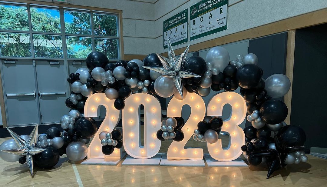 A balloon arch with the lit-up number 