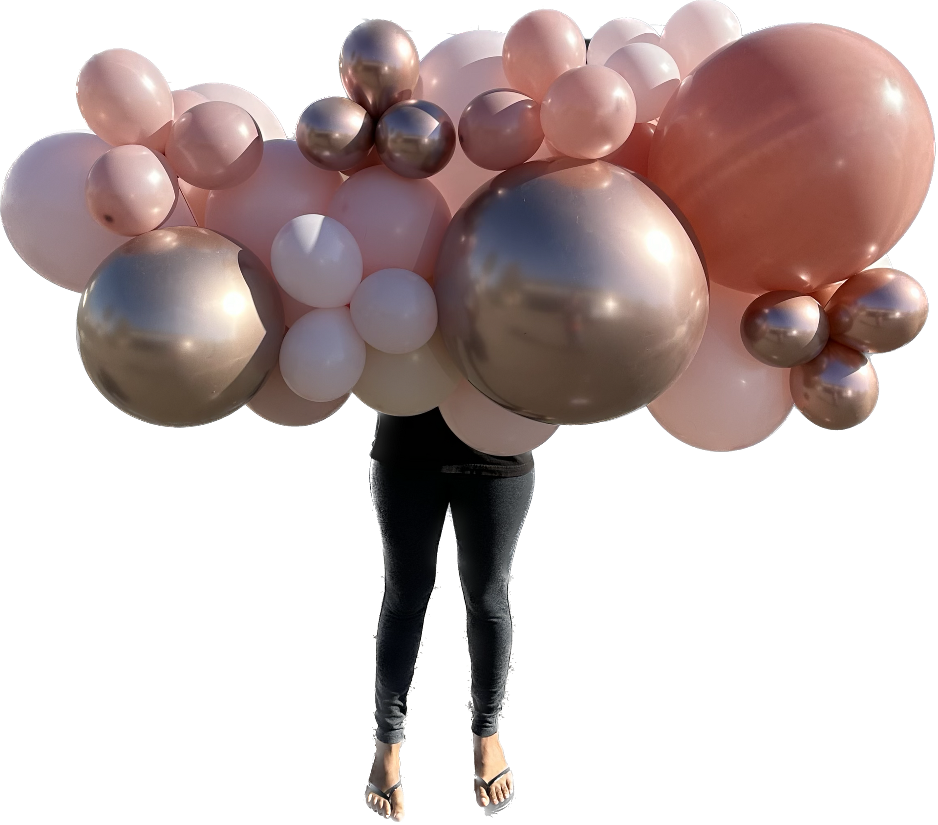 Person holding a large balloon arrangement in shades of pink, rose gold, and white.