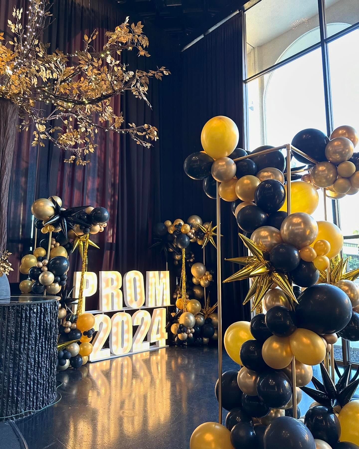 Prom-themed event decorated with black, gold, and yellow balloons.