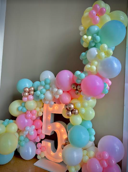 Pastel balloon arch with a light-up number 