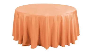 Round table draped with a peach-colored tablecloth.