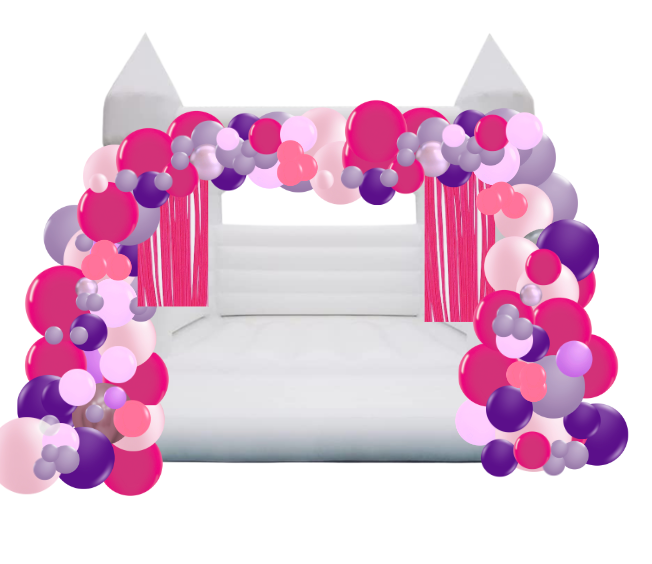 White bouncy castle with pink, purple, and light pink balloon arch.