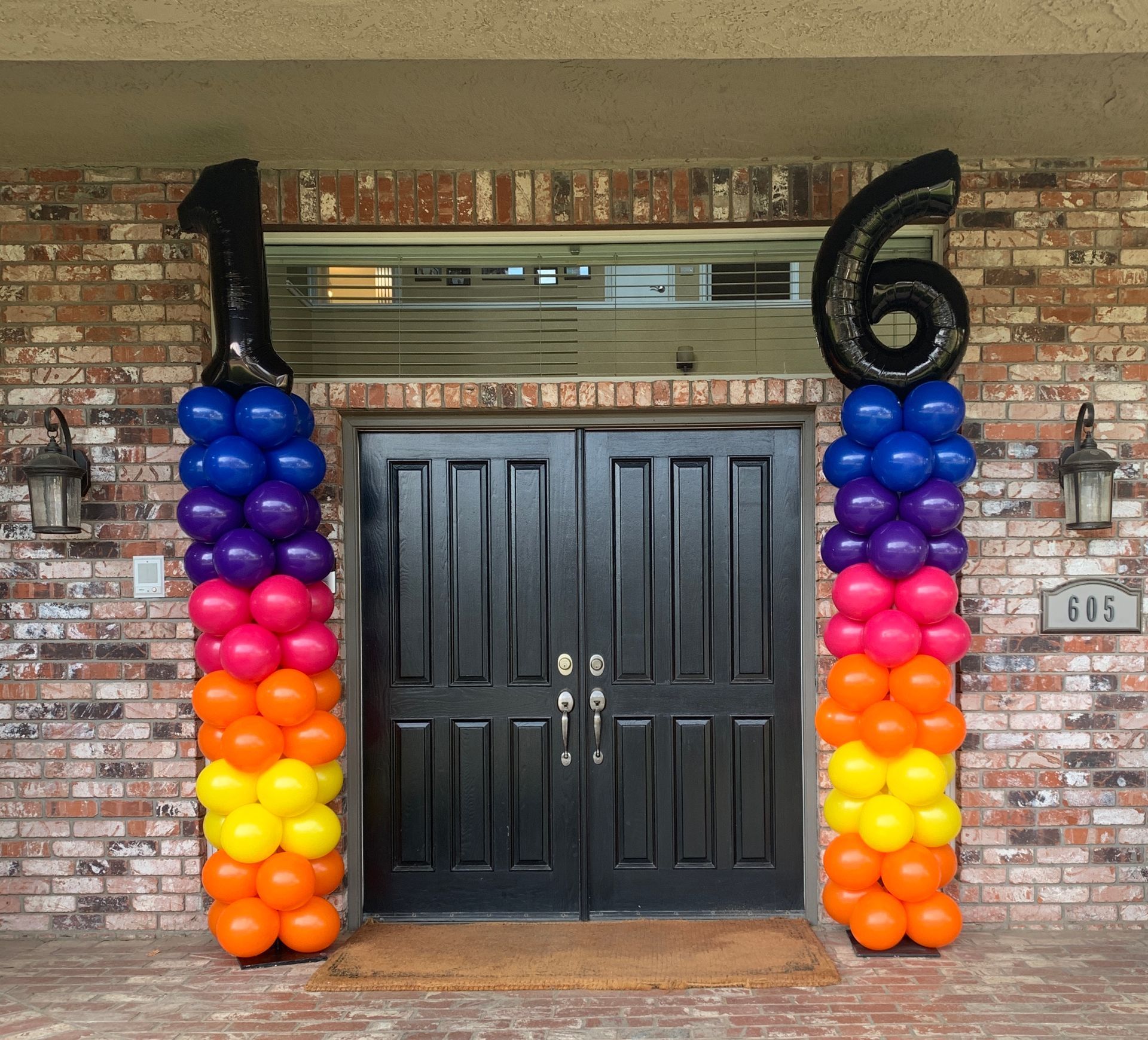 Two balloon columns flanking a door, forming the number 