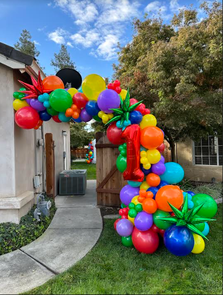 Colorful balloon archway for a first birthday party; doorway entrance.
