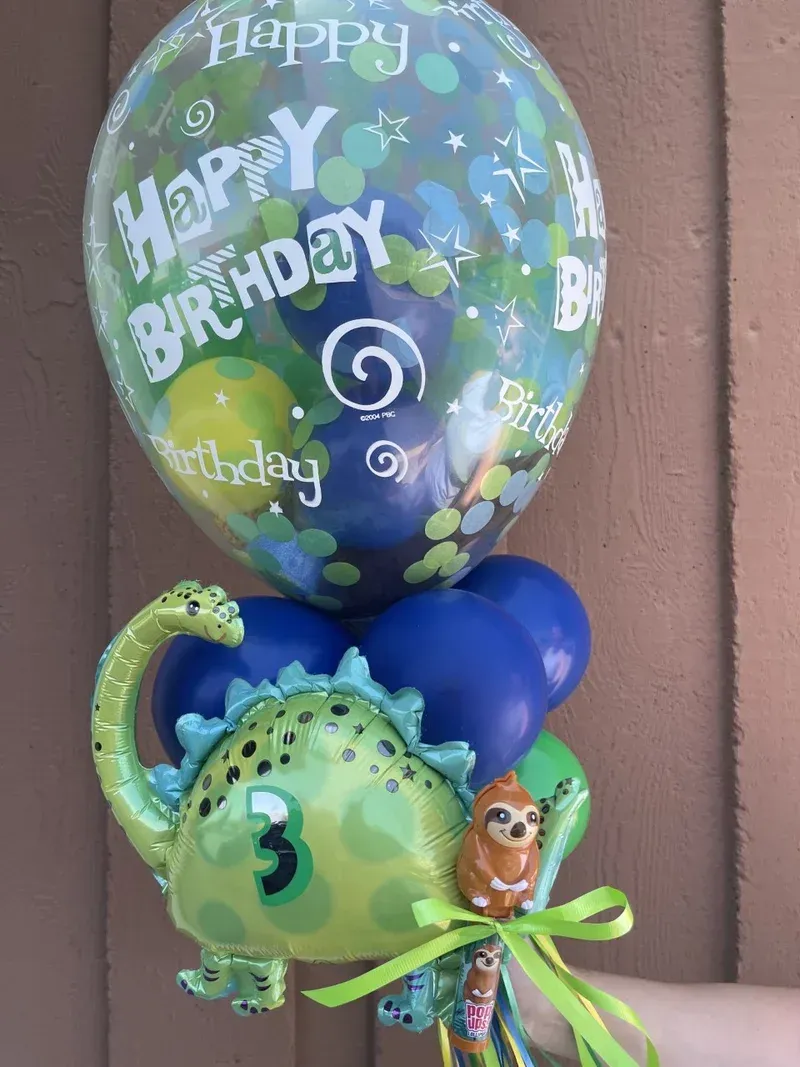 Birthday balloon bouquet with a dinosaur and Happy Birthday text.