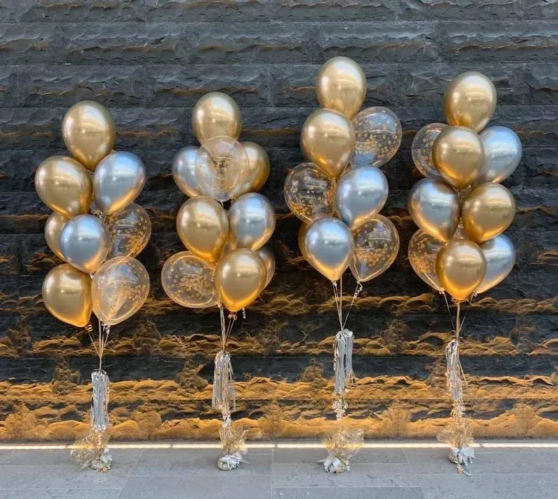 Four balloon bouquets: gold, silver, and confetti-filled balloons arranged on a gold, brown textured background.