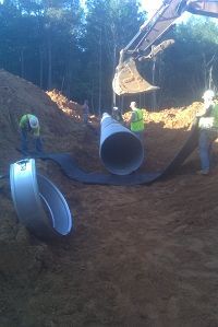 Construction Workers Laying Pipe In Dirt - Oxford, MS - Precision Engineering Corporation